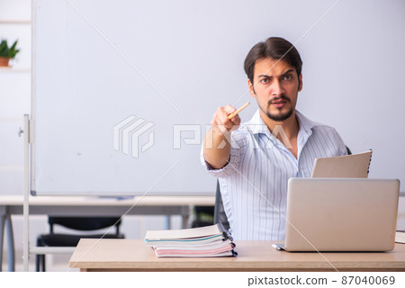 Young male teacher in front of whiteboard Young male teacher in front of whiteboard 87040069