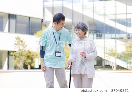 Nursing image portrait of a senior female and a male caregiver taking a walk "LINK FOREST" 87040871