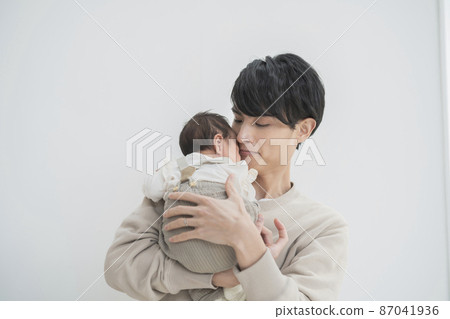 A young father holding a two-month-old baby 87041936