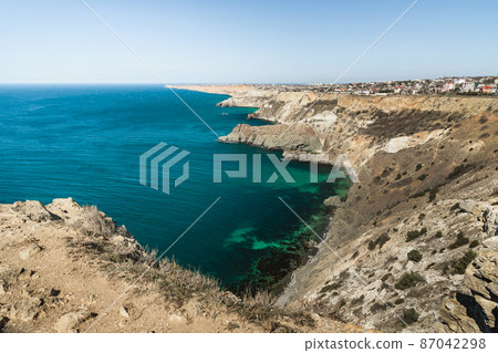 View of Crimean rugged rocky with Diana's Grotto and beach from top of the cliff on Fiolent Cape. Sevastopol. Crimea View of Crimean rugged rocky with Diana's Grotto and beach from top of the cliff on Fiolent Cape. Sevastopol. Crimea 87042298