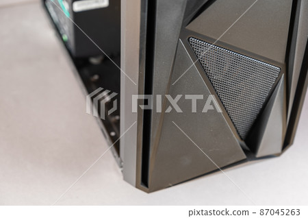 The front of a modern desktop computer. Black system unit in a geometric futuristic design. Digital technology. Close-up. Selective focus 87045263