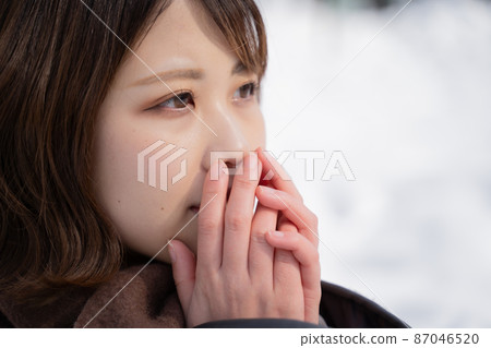 A woman warming her hands 87046520