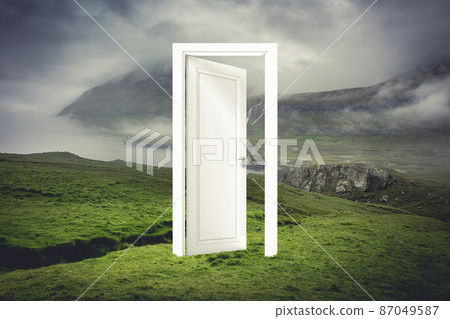 open white door in a natural landscape with sea and land. 87049587
