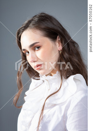 Young woman in office blouse on grey 87050162