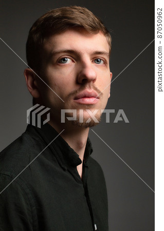 Blond man in black isolated on dark grey Blond man in black isolated on dark grey 87050962