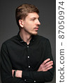 Blond man in black isolated on dark grey 87050974