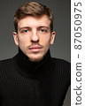 Blond man in black isolated on black 87050975