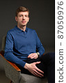 Blond man in blue isolated on black 87050976