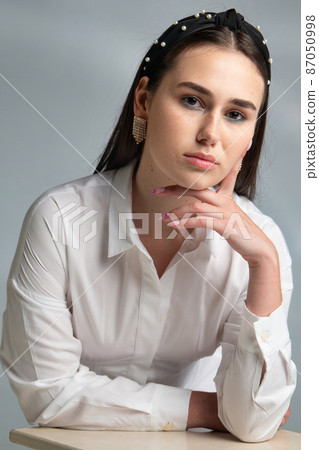 Young woman in office blouse on grey 87050998