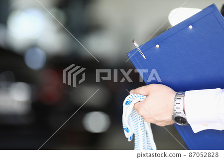 Maintenance center worker hands holding clipboard and working gloves Maintenance center worker hands holding clipboard and working gloves 87052828