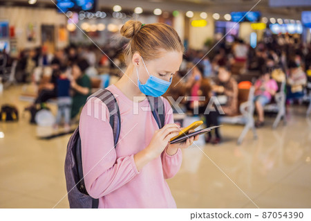 Woman traveler with medical face mask to protection the coronavirus in airport 87054390