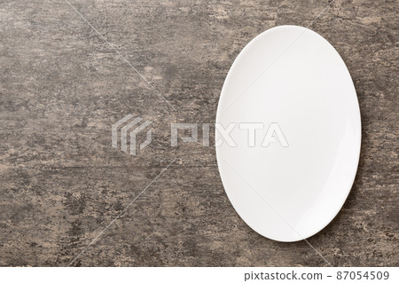 Top view of empty light plate on cement background. Empty space for your design Top view of empty light plate on cement background. Empty space for your design 87054509