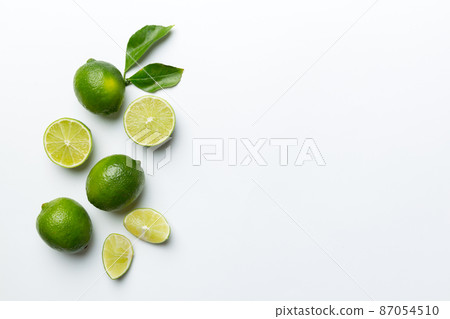 Lime fruits with green leaf and cut in half slice isolated on white background. Top view. Flat lay with copy space Lime fruits with green leaf and cut in half slice isolated on white background. Top view. Flat lay with copy space 87054510