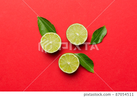 Lime fruits with green leaf and cut in half slice isolated on white background. Top view. Flat lay with copy space Lime fruits with green leaf and cut in half slice isolated on white background. Top view. Flat lay with copy space 87054511