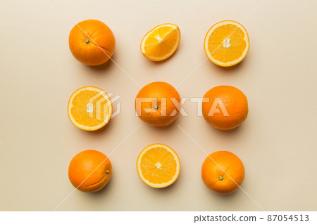 Fruit pattern of fresh orange slices on colored background. Top view. Copy Space. creative summer concept. Half of citrus in minimal flat lay Fruit pattern of fresh orange slices on colored background. Top view. Copy Space. creative summer concept. Half of citrus in minimal flat lay 87054513