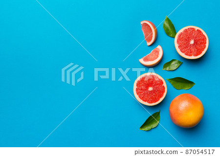 fresh Fruit grapefruit with Juicy grapefruit slices on colored background. Top view. Copy Space. creative summer concept. Half of citrus in minimal flat lay with copy space fresh Fruit grapefruit with Juicy grapefruit slices on colored background. Top view. Copy Space. creative summer concept. Half of citrus in minimal flat lay with copy space 87054517
