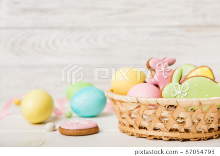 Colorful easter cookies in basket with Multi colors Easter eggs on colored background . Pastel color Easter eggs. holiday concept with copy space 87054793