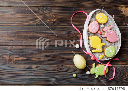 Colorful easter cookies in basket with Multi colors Easter eggs on colored background . Pastel color Easter eggs. holiday concept with copy space Colorful easter cookies in basket with Multi colors Easter eggs on colored background . Pastel color Easter eggs. holiday concept with copy space 87054798