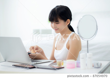 Beauty of young asian woman with learning makeup with powder puff on cheek. Beauty of young asian woman with learning makeup with powder puff on cheek. 87054970