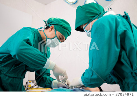 Group of team doctor and surgeon doing surgery with patient in the operation at hospital. Group of team doctor and surgeon doing surgery with patient in the operation at hospital. 87054971