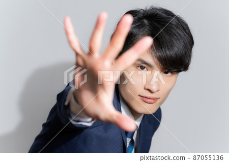 Portrait of a young man in a suit that spreads his hands Portrait of a young man in a suit that spreads his hands 87055136