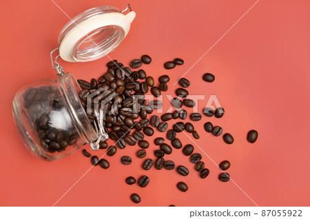 Roasted Coffee beans in a glass jar top view on pink background Roasted Coffee beans in a glass jar top view on pink background 87055922