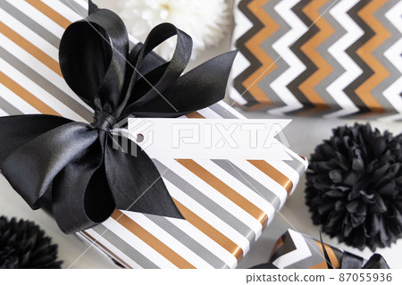 Wrapped present with blank horizonal gift tag and black bow close up, label Mockup Wrapped present with blank horizonal gift tag and black bow close up, label Mockup 87055936