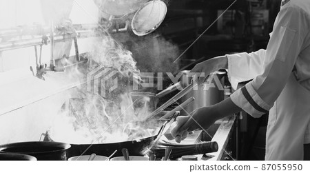 Chef stir fry busy cooking in kitchen Chef stir fry busy cooking in kitchen 87055950
