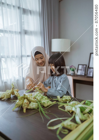 muslim mother teach her daughter how to make a ketupat for eid mubarak muslim mother teach her daughter how to make a ketupat for eid mubarak 87056480