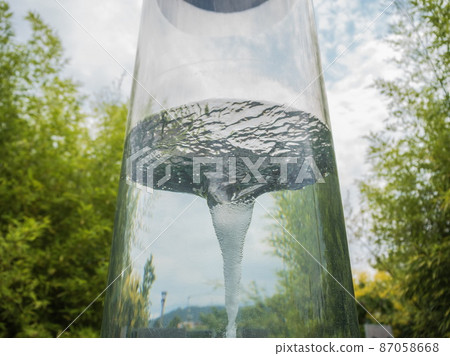 Water in glass cylindrical flask creates a tornado park Sochi Water in glass cylindrical flask creates a tornado park Sochi 87058668
