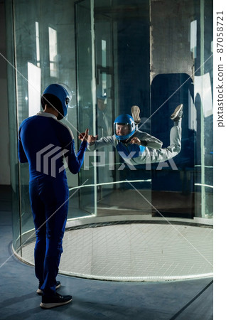 A man trains a woman as an astronaut. Classes on flying in a wind tunnel. 87058721