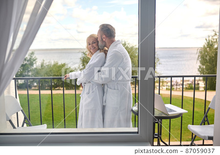 A couple at the balcony hugging and feeling amazing A couple at the balcony hugging and feeling amazing 87059037