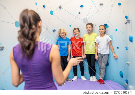 Schoolchildren standing near wall looking at coach Schoolchildren standing near wall looking at coach 87059084