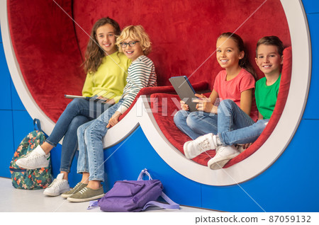 Classmates sitting resting looking at camera Classmates sitting resting looking at camera 87059132