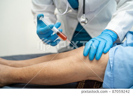 Asian doctor inject Hyaluronic acid platelet rich plasma into the knee of senior woman to walk without pain. 87059242