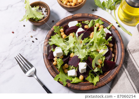 Healthy spring salad beet with spinach, cheese feta and chickpeas on a marble tabletop. 87060254