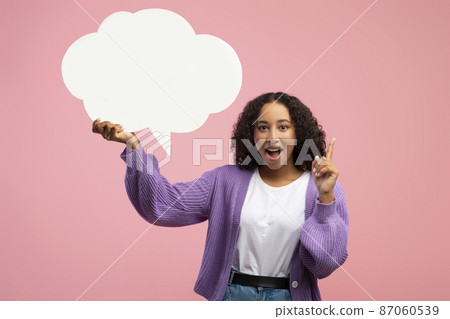 Excited young black woman holding empty speech bubble and pointing up, having creative idea on pink studio background Excited young black woman holding empty speech bubble and pointing up, having creative idea on pink studio background 87060539