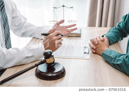 Male lawyer is meeting with businessman client to discuss consultation with litigation contract papers document of estate working in a workplace 87061016