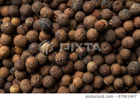 Allspice jamaica pepper texture background. Dried brown berries of the Pimenta dioica tree. 87061407