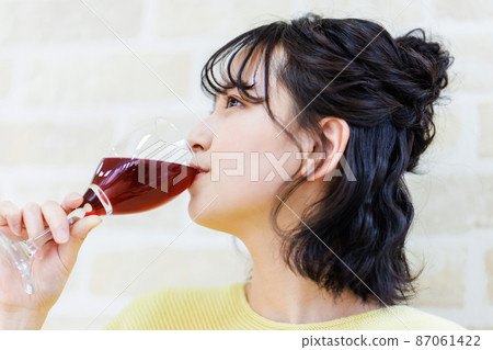 Female drinking wine at home 87061422