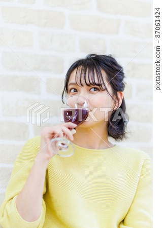 Female drinking wine at home 87061424