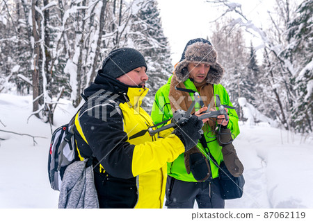 two men in the winter forest launch a quadcopter two men in the winter forest launch a quadcopter 87062119