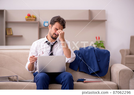 Young male employee working from home during pandemic 87062296