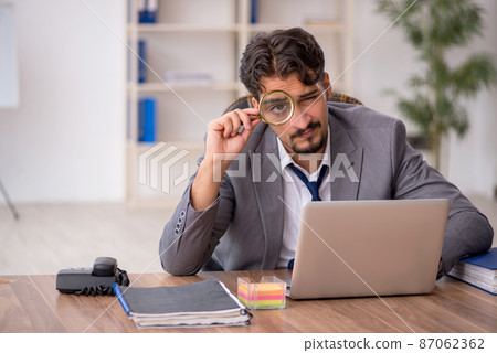 Young male employee sitting in the office 87062362