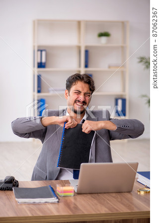Young male employee sitting in the office 87062367