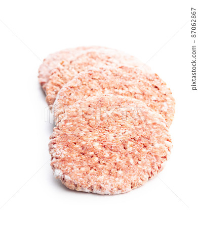 Frozen hamburger meat. Raw beef patties isolated on white background. Frozen hamburger meat. Raw beef patties isolated on white background. 87062867