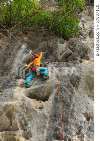 Female rock climber on cliff 87067110