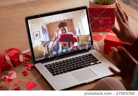 Happy african american young man waving to biracial girlfriend during video call on valentine day Happy african american young man waving to biracial girlfriend during video call on valentine day 87069760