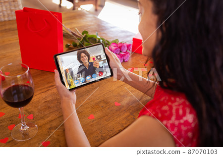 Happy biracial young man showing ring to girlfriend while online dating on valentine day Happy biracial young man showing ring to girlfriend while online dating on valentine day 87070103