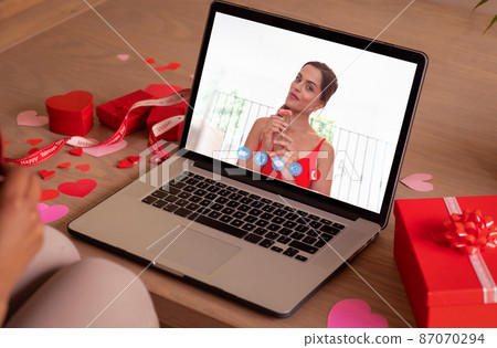 Smiling caucasian young woman dating with girlfriend on video call during valentine day Smiling caucasian young woman dating with girlfriend on video call during valentine day 87070294